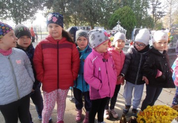 Powiększ obraz: Starszaki palą znicze na cmentarzu